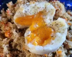 Step <p><span style="font-weight: normal;">Repartir la quinoa en 4 platos, poner sobre cada uno un huevo mollet abierto por la mitad, regar con un chorrito de aceite de oliva y espolvorear al gusto con pimienta negra recién molida. Servir inmediatamente.</span></p> illustration