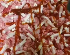 Step <p>cubrimos la superficie con salsa barbacoa y echamos por encima el queso para gratinar.</p> illustration